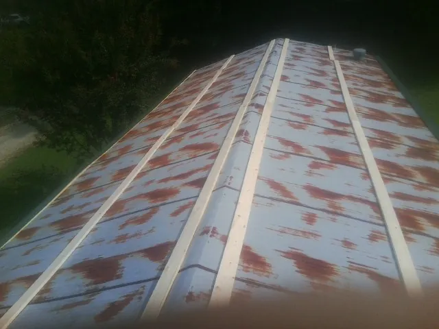 Rusted metal roof panels with new wood purlins before replacement — Storm Damage Roof Repair in Roxobel by Roofing Brothers