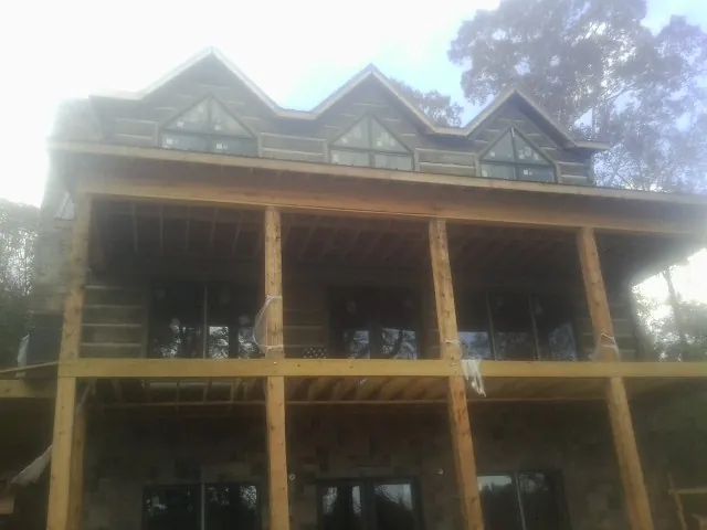 Dormers and porch framing on a large log home under construction — Roof Coating work by our crew in Roxobel